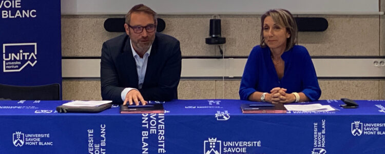 Deux personnes assises à une table pour signer une document