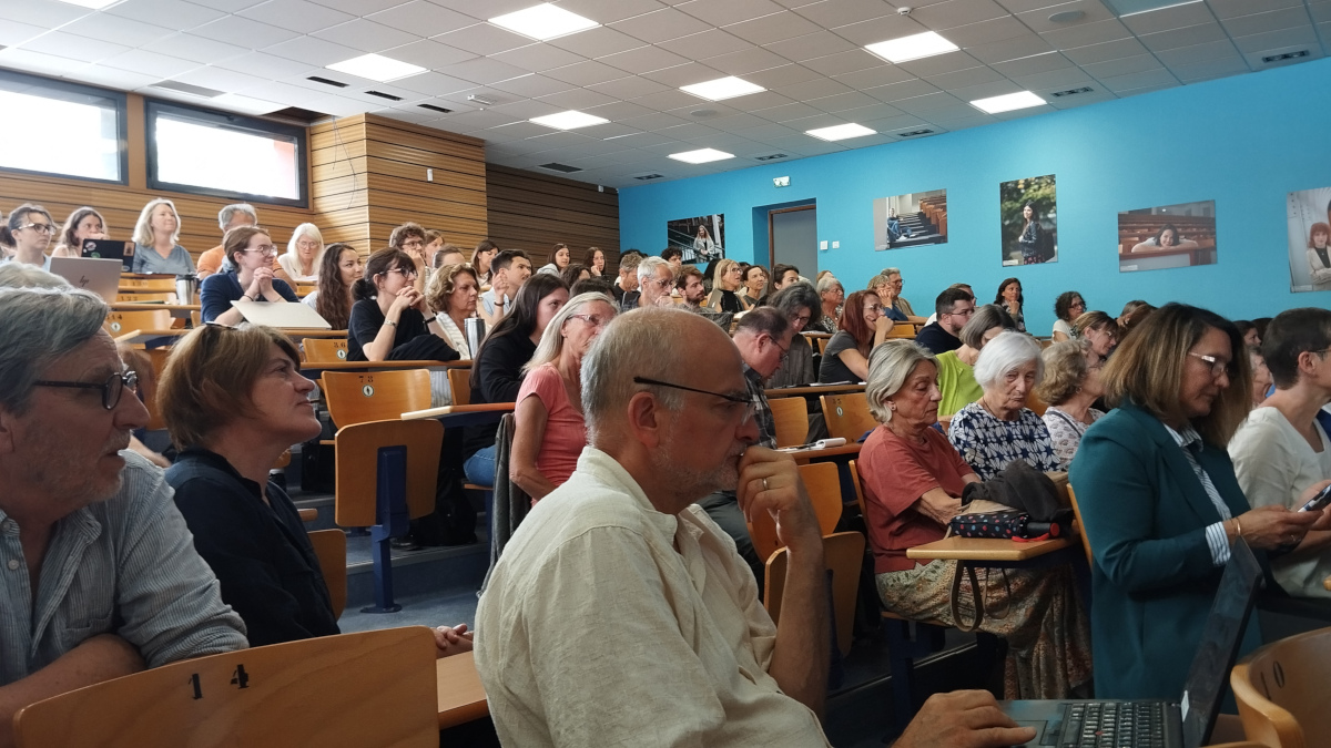 Un public en nombre dans une salle ; venu assister à une conférence.